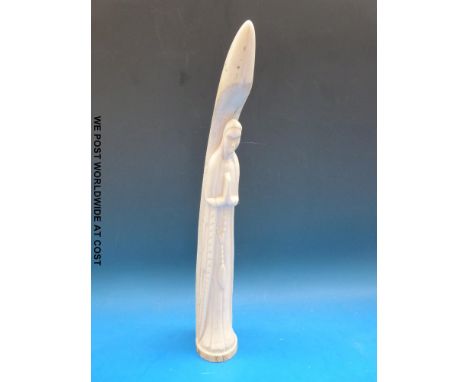 A large ivory tusk carved with a nun holding a pendant, 42 cm long