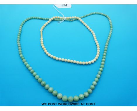 A graduated jade bead necklace (69cm) and an early 20thC ivory bead example (41cm)
