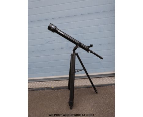 A Tasco 60mm refractor telescope on tripod with additional eye pieces and paper work
