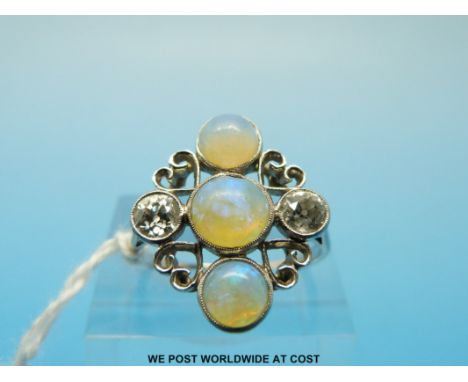 An 18ct white gold ring set with three opal cabochons and two Old English cut diamonds of approximately 0.3ct each (size P) 