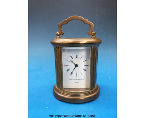 A minature oval brass carriage clock by Matthew Norman London (7cm tall)