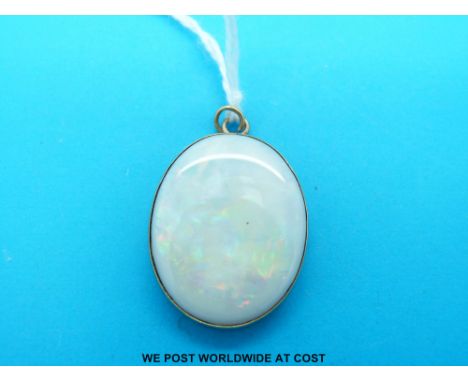 A yellow metal pendant set with a large oval opal cabochon