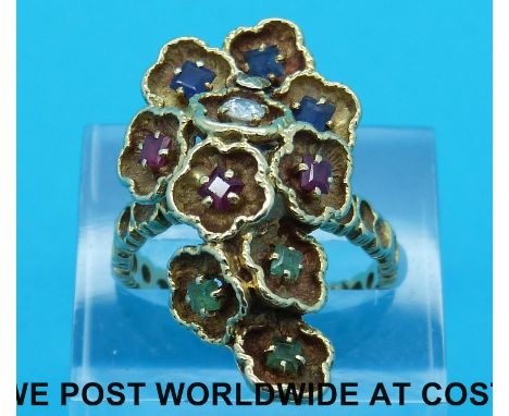 An 18ct gold ring made up of ten petal shapes set with three square sapphires, three square rubies, three square emeralds and