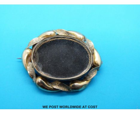 A yellow metal mourning brooch with portrait verso