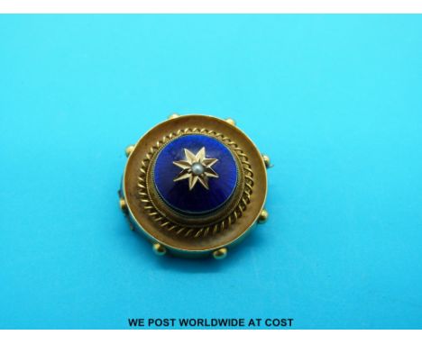A Victorian yellow metal brooch with a seed pearl set in a star to the centre of a circle of blue guilloché enamel surrounded
