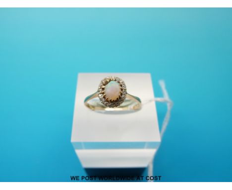 A yellow metal ring set with an oval opal surrounded by diamonds, size O/P (1.8g) 