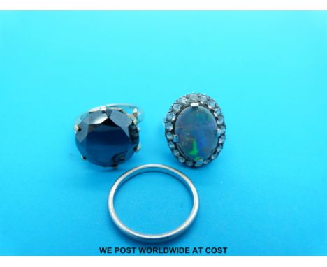 A 9ct gold ring, an 18ct white gold wedding band and a white metal ring set with an opal doublet surrounded by white sapphire