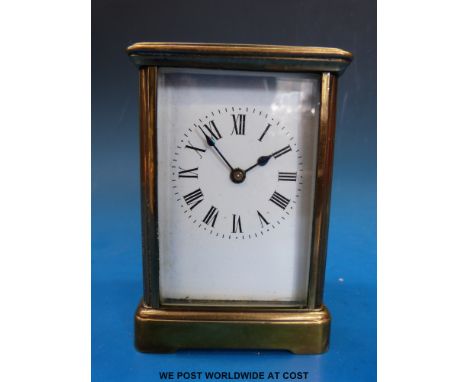 A brass cased carriage clock in corniche style case with white enamel dial.
