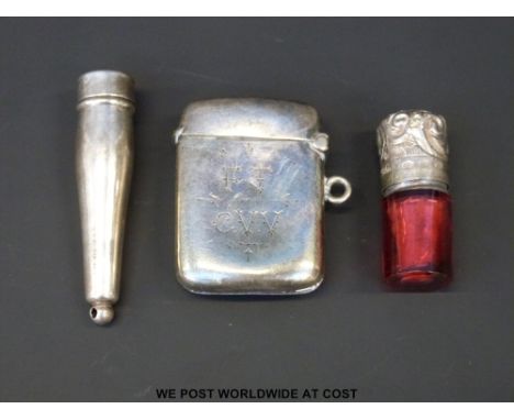 A hallmarked silver vesta, hallmarked silver case and a Victorian cranberry glass scent bottle with hallmarked silver top, he