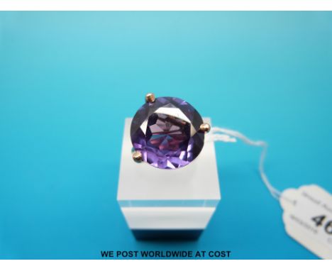 A yellow metal ring set with a large round cut purple sapphire, size K (8.9g) 