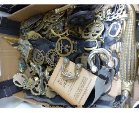 A large collection of horse brasses, both loose and on straps, brass table cannon, door knockers, currency bangles, crocodile