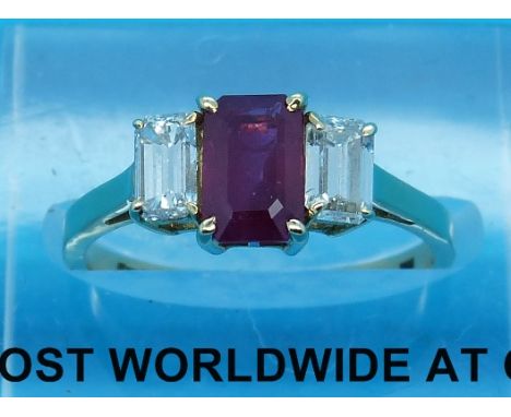 An 18ct gold ring set with an emerald cut ruby flanked by two emerald cut diamonds 