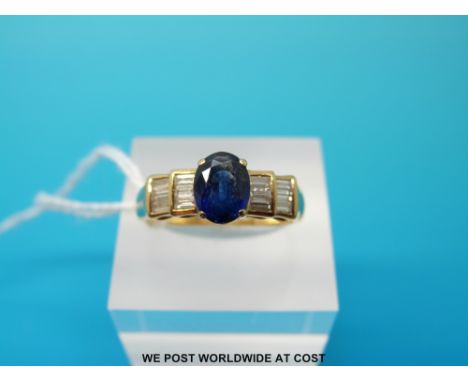 An 18ct gold ring set with an oval sapphire and baguette cut diamonds, size Q/R (6g)