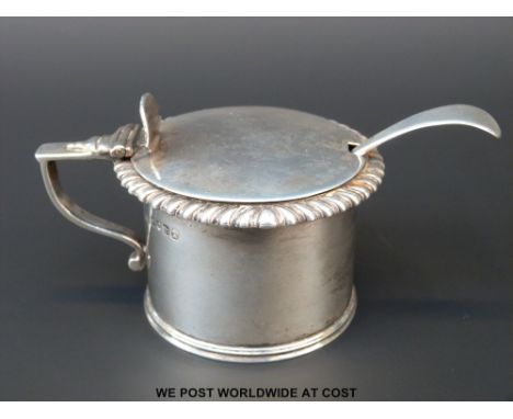 A Georgian hallmarked silver mustard with blue glass liner and gadrooned edge, length 10cm, London 1827, maker Rebecca Emes &