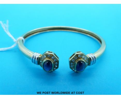 A yellow metal bangle marked 750 set with sapphires and diamonds (15g)