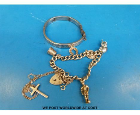 A silver charm bracelet, silver bangle and silver cross