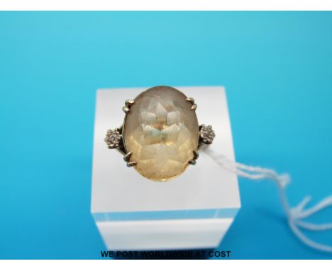 A 9ct ring set with a large oval quartz flanked by two diamonds, size K/L (4.9g) 