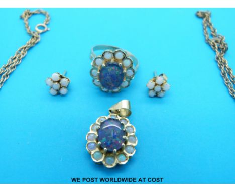 A yellow metal ring and pendant marked 14k set with a central oval opal surrounded by smaller circular opals on a 9ct gold ch