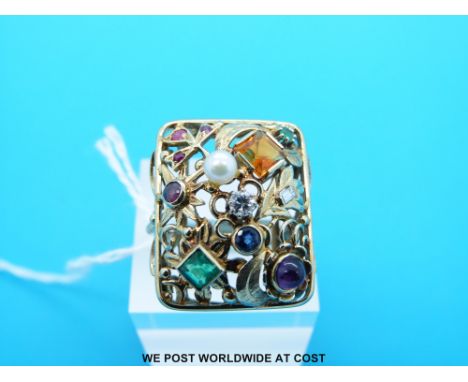 A yellow metal ring marked 14ct set with emeralds, a sapphire, a garnet, diamonds, citrine, a pearl, amethyst and rubies in a