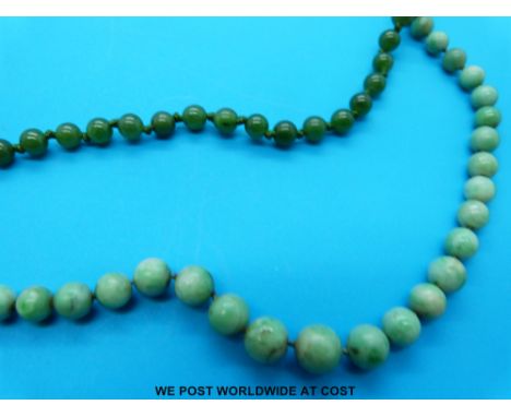 A jadeite necklace made up of graduated spherical beads and a similar spinach jade example