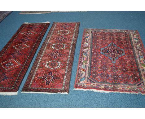 TWO SIMILAR WOOLLEN BOKARA STYLE RED GROUND CARPET RUNNERS, length 191cm, together with an tajabad style red ground rug (3)