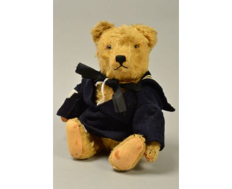 A GOLDEN PLUSH TEDDY BEAR, glass eyes, vertical stitched nose, jointed body, original damaged felt pads with four stitched cl