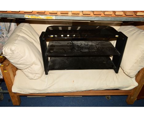 A SOLID GOLDEN OAK SOFA BED with cream cushions and a foldable mattress, width 152cm