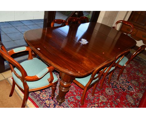 A VICTORIAN MAHOGANY EXTENDING DINING TABLE OF RECTANGULAR FORM, rounded ends, lacks wind out mechanism, on four turned and f