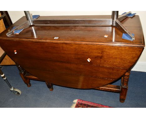 A REPRODUCTION OAK OVAL TOPPED GATE LEG TABLE 