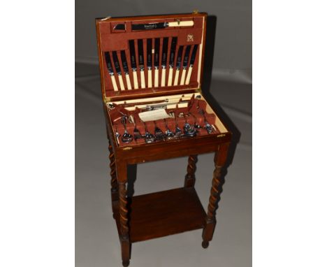 A 1930'S OAK CASED TABLE CANTEEN ON BARLEY TWIST LEGS, fitted with chrome plated Old English pattern cutlery