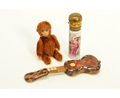 THREE ITEMS, to include a Schuco monkey (feet missing, well worn), an early 20th Century miniature guitar with tortoiseshell 