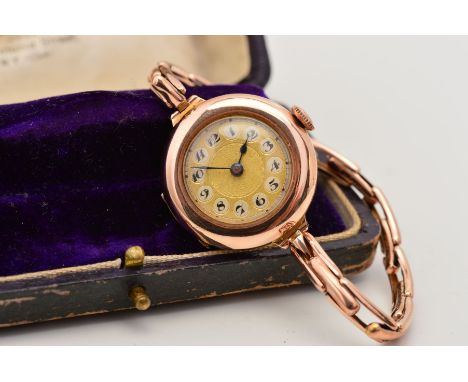AN EARLY 20TH CENTURY 9CT GOLD WRISTWATCH, the circular face with central engine turned sun ray detail, Arabic numerals and e