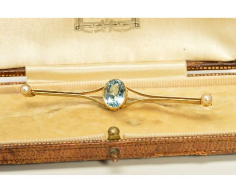 AN EARLY 20TH CENTURY AQUAMARINE AND SEED PEARL BAR BROOCH, the central oval aquamarine within a millegrain setting to the ta