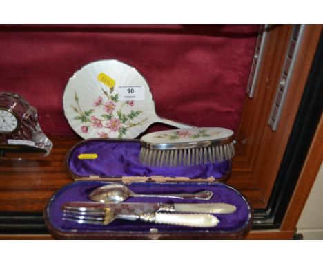 An enamel decorated hand mirror and brush; together with three piece Christening set in leather case