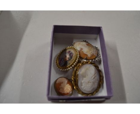 Three various cameo brooches; and a portrait brooch 