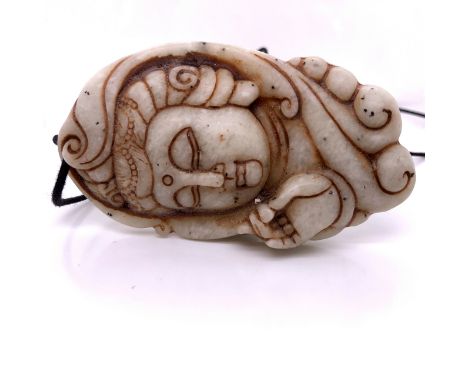 AN ORIENTAL CARVED JADE PENDANT DEPICTING A DEITY 8.5 cm HIGH