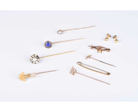 A small collection of stick pins, comprising, a yellow metal heart example, stamped '9', a yellow metal bar, stamped '9ct', t