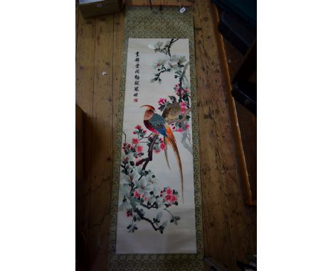 A Chinese silk embroidered scroll, decorated with pheasants in a flowering branch, signed and inscribed, the panel 146 x 46cm