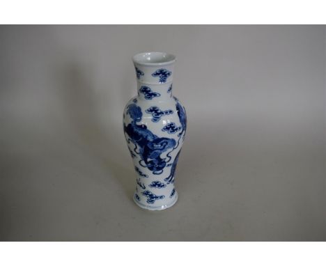 A Chinese blue and white inverted baluster vase, Kangxi four character mark, painted with shi shi dogs, 27cm high, (glaze chi