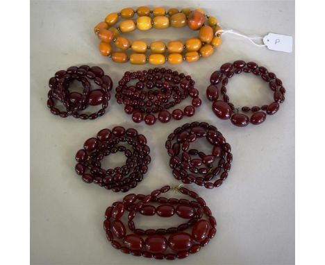 Six 'cherry' amber style oval bead necklaces; together with another 'toffee' amber style necklace. (7) Condition Report: One 