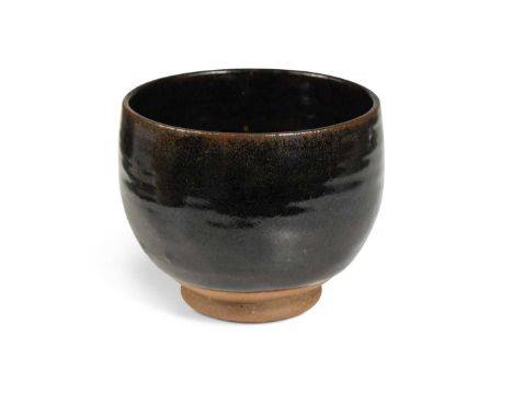 § Norah Braden (British, 1901-2001), a small stoneware bowl, decorated with a tenmoku glaze and raised on a small, unglazed f