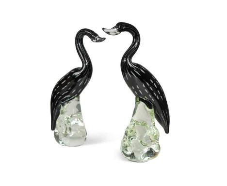 A pair of stylised Murano glass swans, the black cores embellished with white canes and cased in clear glass33cm highIn good 