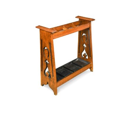 An Arts &amp; Crafts oak umbrella/stick stand, the triangulated and pierced silhouette ends united by three dividers and a me