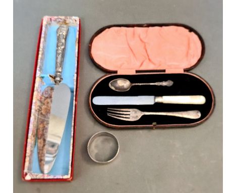 A cased non-matching set of 3 to include a fork, a small teaspoon and a spread knife together with a silver napkin ring and a