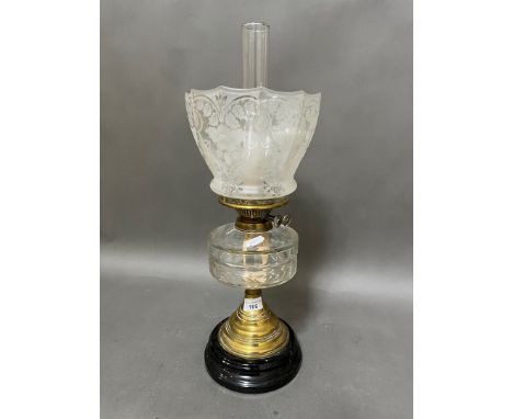 A brass oil lamp with cut glass reservoir and etched glass shade.Condition:-General wear through age and use, very small chip