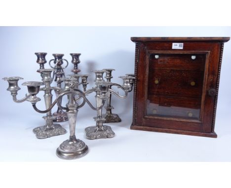 Early 20th Century oak chest of draws with bevelled glazed front H38cm, set of three silver-plated candelabra and two others 
