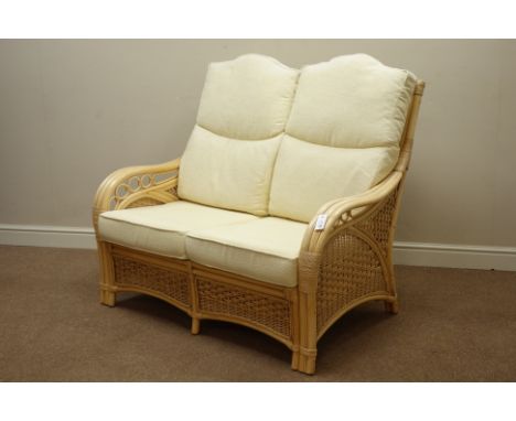 Cane and bamboo two seat sofa with loose cushions upholstered in cream fabric, W126cm