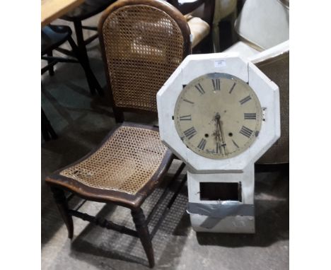 A caned nursing chair and a white painted wall clock