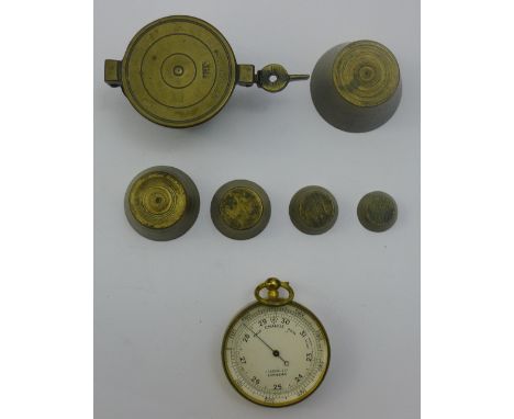 A Victorian pocket barometer and a set of bronze cup weights