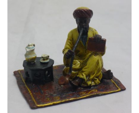 A cold painted bronze figure of a man smoking